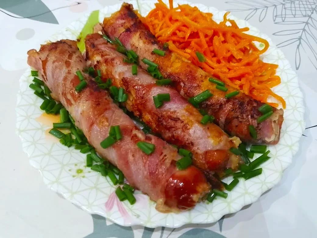 Обжаренные на сковороде, сосиски с сыром, в беконе