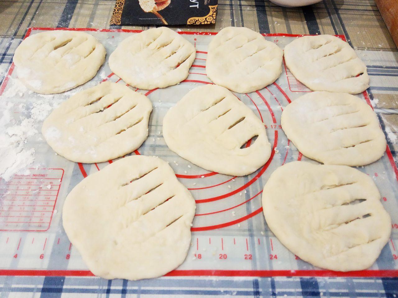 Жареные пончики без яиц с начинкой и с кунжутом: С той стороны где посыпали кунжутом делаем надрезы.