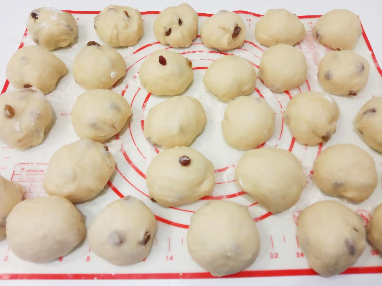 Булочки с изюмом в мучной крошке, воздушные и вкусные: Когда тесто увеличится в объеме, разделяем на 30 колобков. Колобки накрываем и оставляем на 10-15 минут.