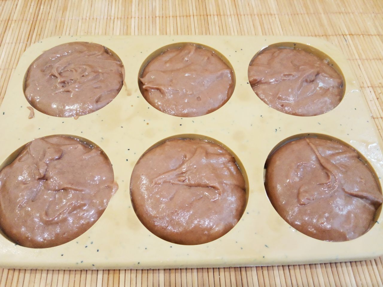 Вафли шоколадные, мягкие, ароматные и вкусные: Силиконовые формы смазываем жиром и ложкой накладываем тесто до половины формочки.