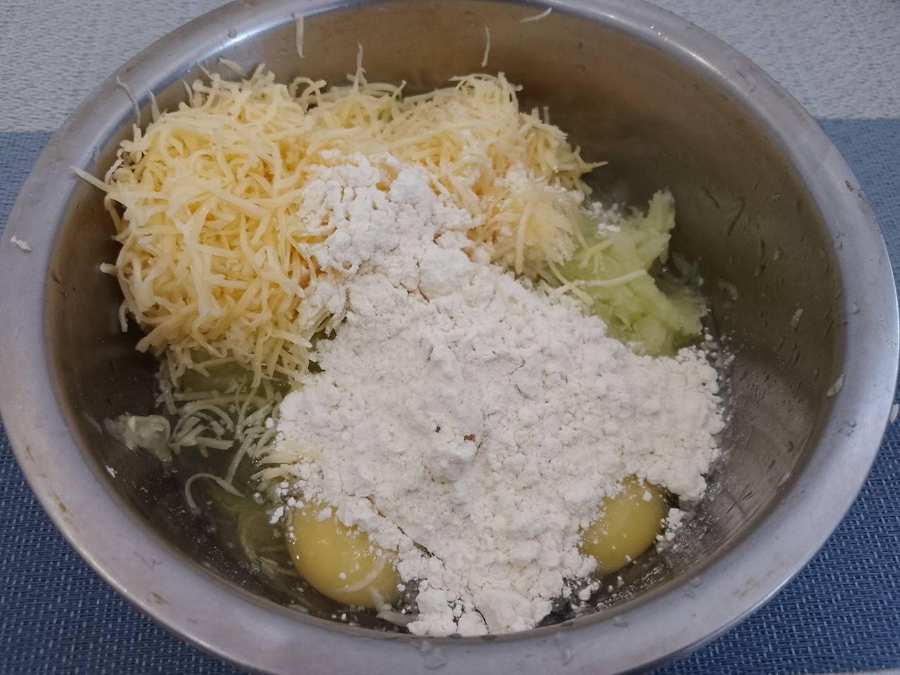 Оладьи из кабачков и сыра, просто и вкусно: Добавляем к отжатым кабачкам тертый сыр, яйца, чеснок и муку. Кабачковую массу тщательно размешиваем.