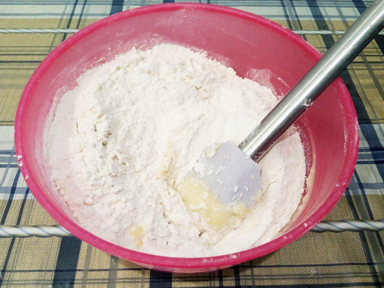 Печенье без яиц, с кунжутом и кокосовой стружкой: Всыпаем частями в смесь муку, размешиваем лопаткой и замешиваем нежное тесто. Тесто на полчаса помещаем в