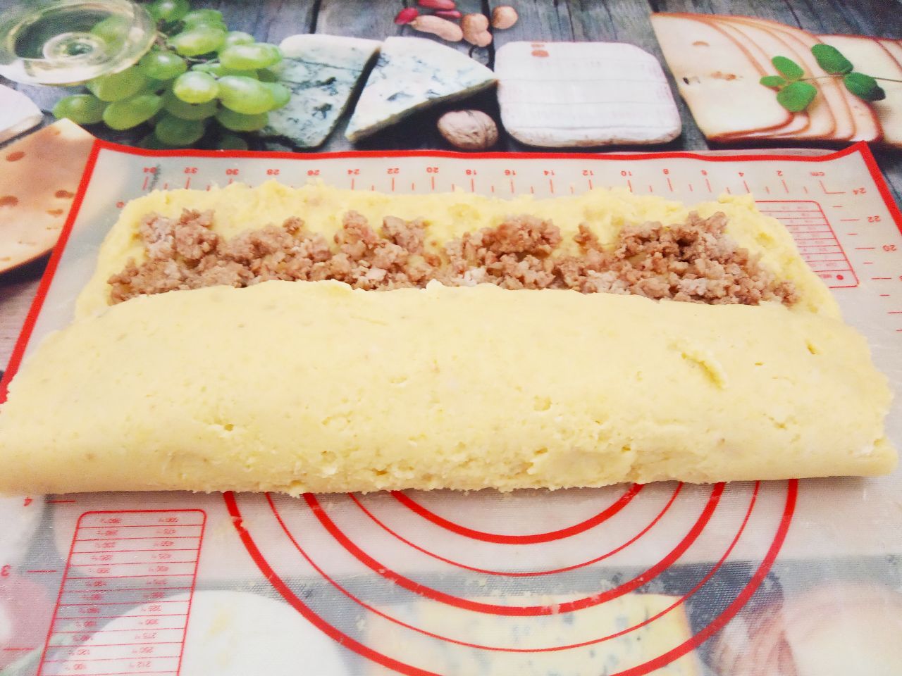 Картофельный рулет с мясной начинкой, запеченный в духовке: С помощью пленки или коврика, закрываем начинку с одной стороны.