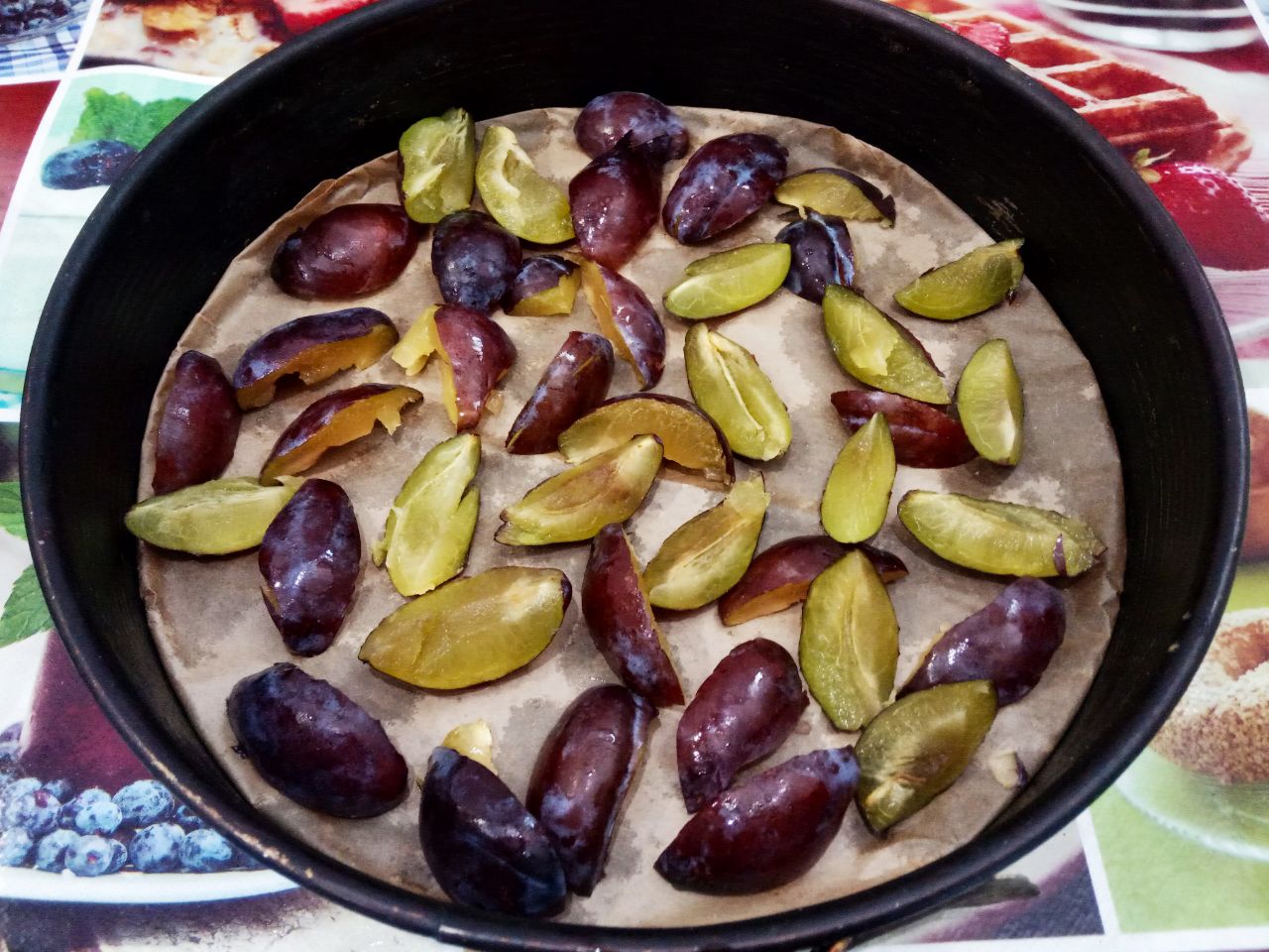 Пирог из бисквитного теста со сливами, просто и вкусно: Форму для пирога, у меня форма диаметром 26 см, застилаем пергаментом и выкладываем половину долек слив.