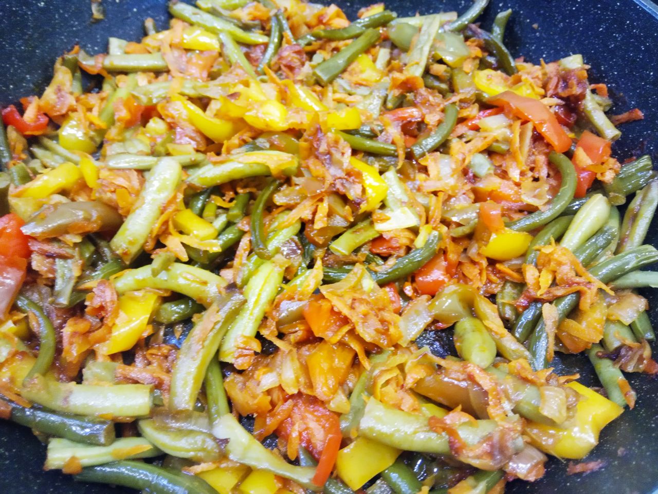 Тушеные замороженные овощи, полезно и вкусно: Кладем в сковороду полоски перца, стрелки чеснока, спаржевую фасоль и два лавровых листочка. Овощи