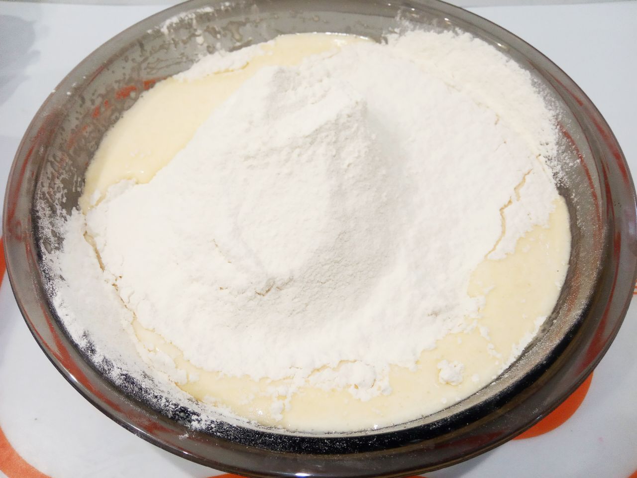 Пирог с яблоками на кефире и растительном масле, просто и вкусно: Муку просеиваем через мелкое сито и добавляем в смесь, размешиваем.