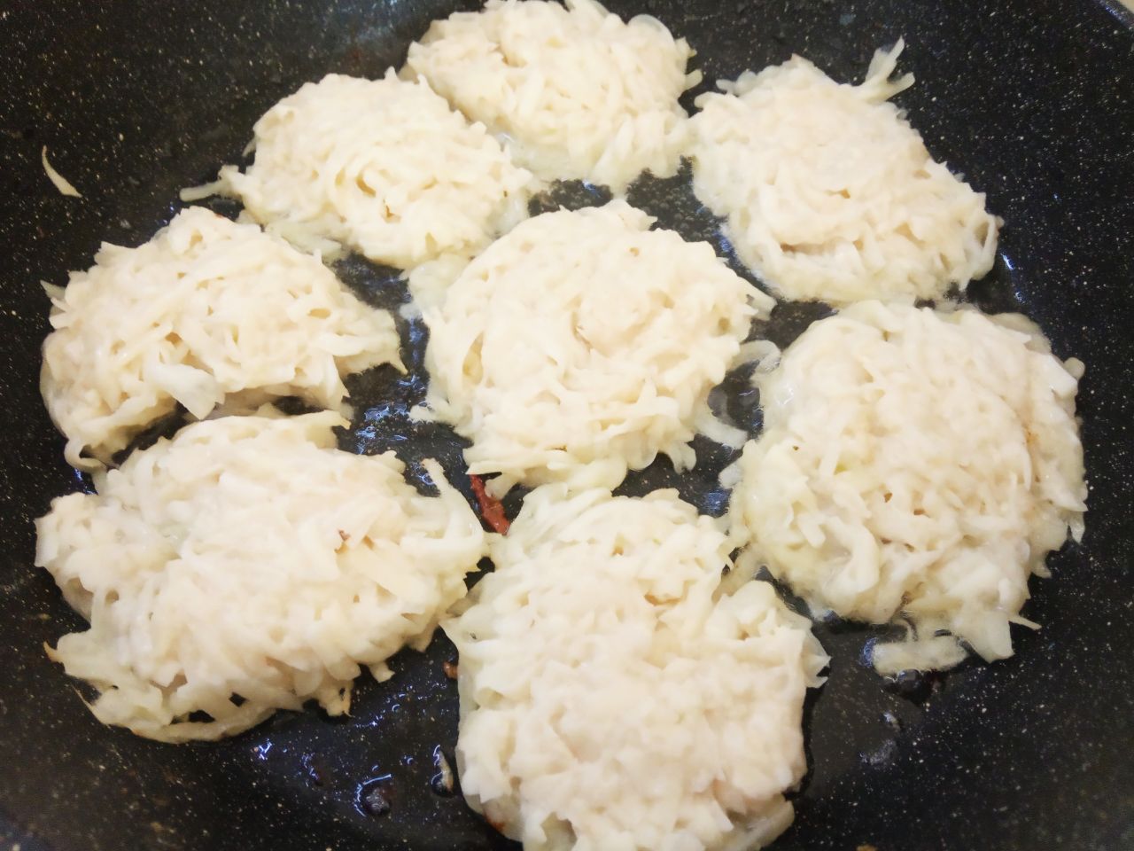 Картофельные колдуны с фаршем и сыром, вкусно и сытно: Разогреваем сковороду с растительным маслом и ложкой выкладываем картофельную основу, разравниваем.