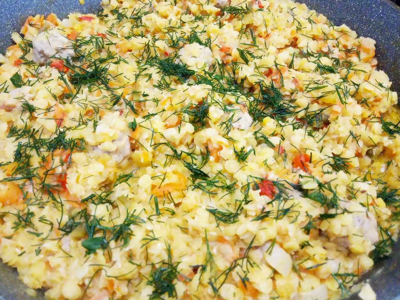 Красная чечевица тушеная с овощами и мясными шариками: Зелень промываем, просушиваем и измельчаем. Посыпаем чечевицу измельченной зеленью по вкусу и снимаем с огня.
