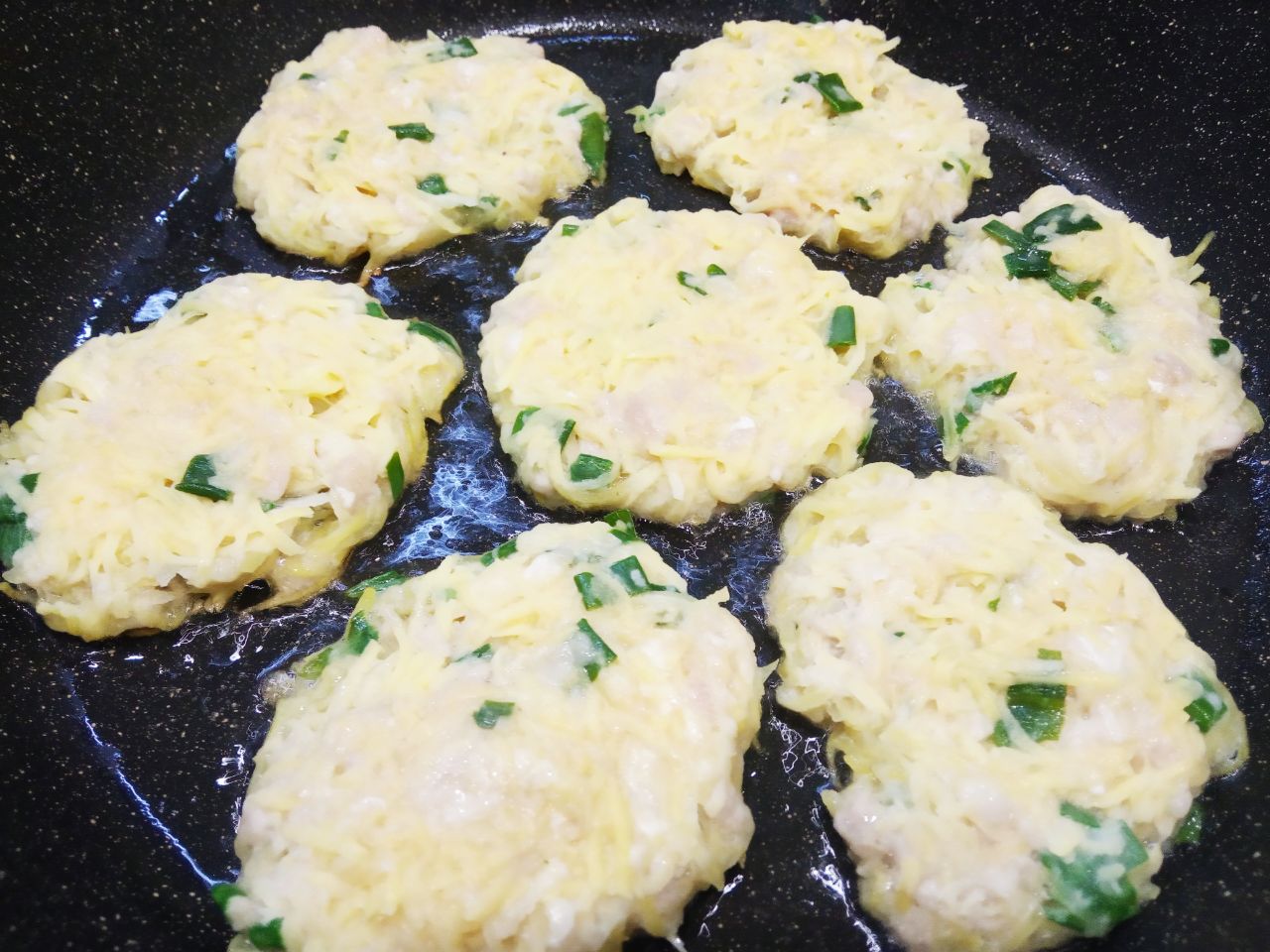 Картофельные оладьи с добавлением мясного фарша и зеленого лука: Разогреваем сковороду с растительным маслом, выкладываем ложкой тесто для оладий, разравниваем.