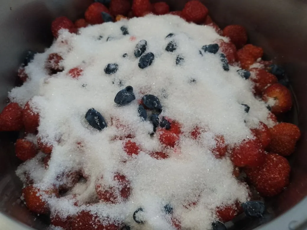 Желе из ягод клубники и жимолости, нежное и вкусное: Часть ягод оставляем для украшения, оставшиеся ягоды засыпаем сахаром и выдерживаем пару часов.
