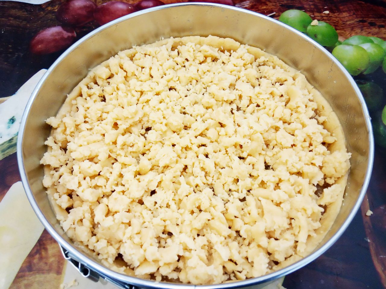 Песочный и рассыпчатый пирог со свежими яблоками: Меньшую часть разделяем на частички и выкладываем равномерно на начинку.