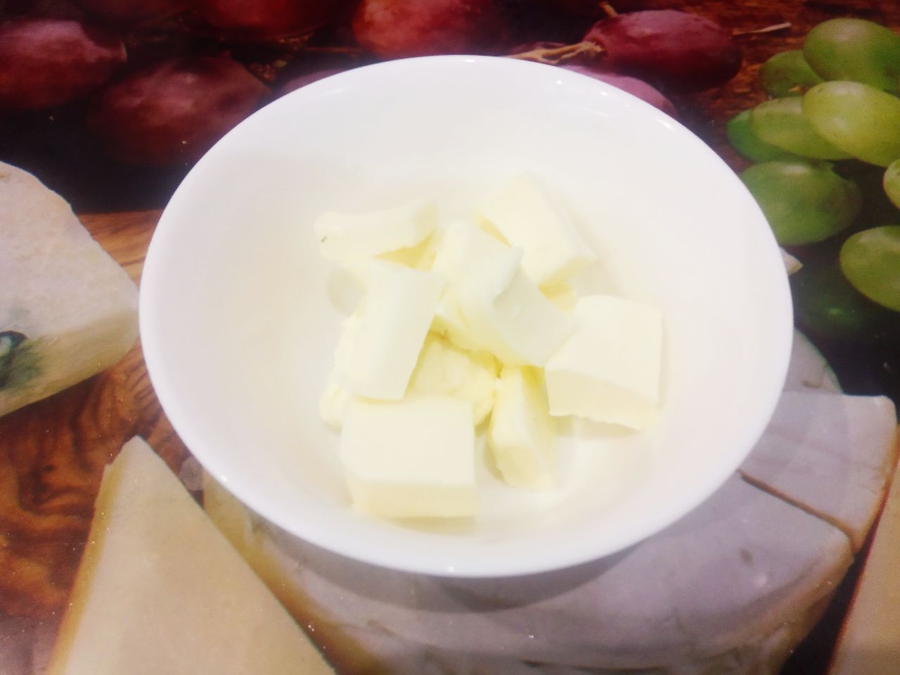Десерт из творога и изюма, просто и вкусно: Размягченное сливочное масло разрезаем на небольшие кусочки.