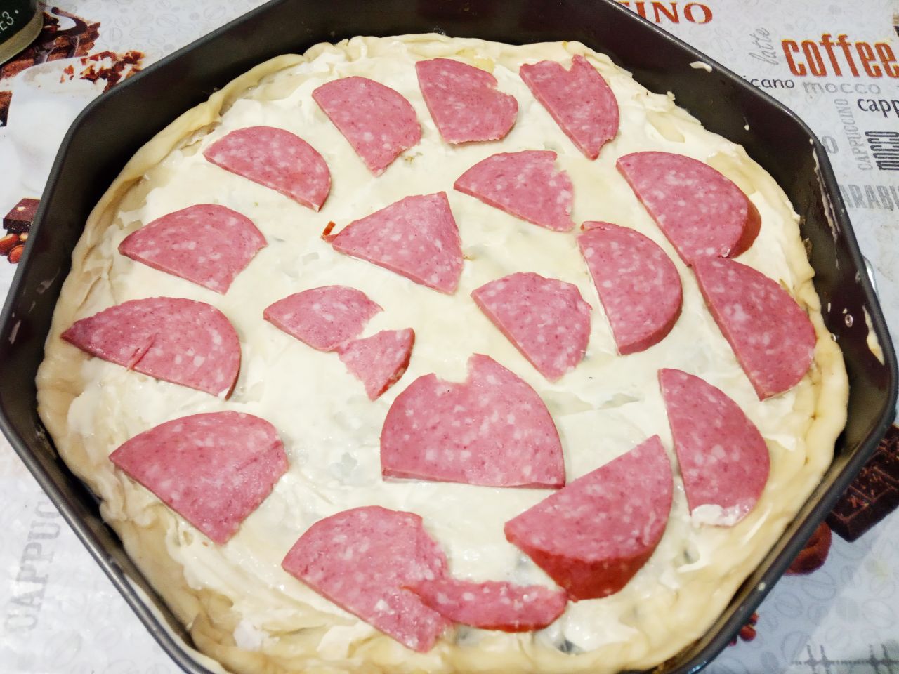 Домашняя пицца с колбасой, помидорами и сладким перцем: Колбасу нарезаем тонкими ломтиками и выкладываем на лист теста.