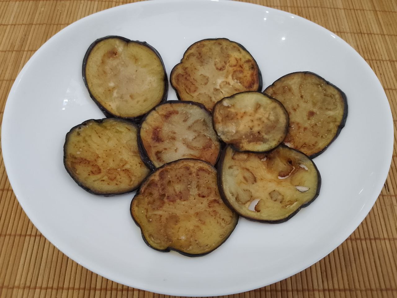 Салат из жареных баклажанов, помидоров, перца, чеснока и зелени, вкусный и аппетитный: На дно салатницы выкладываем ряд баклажанов.