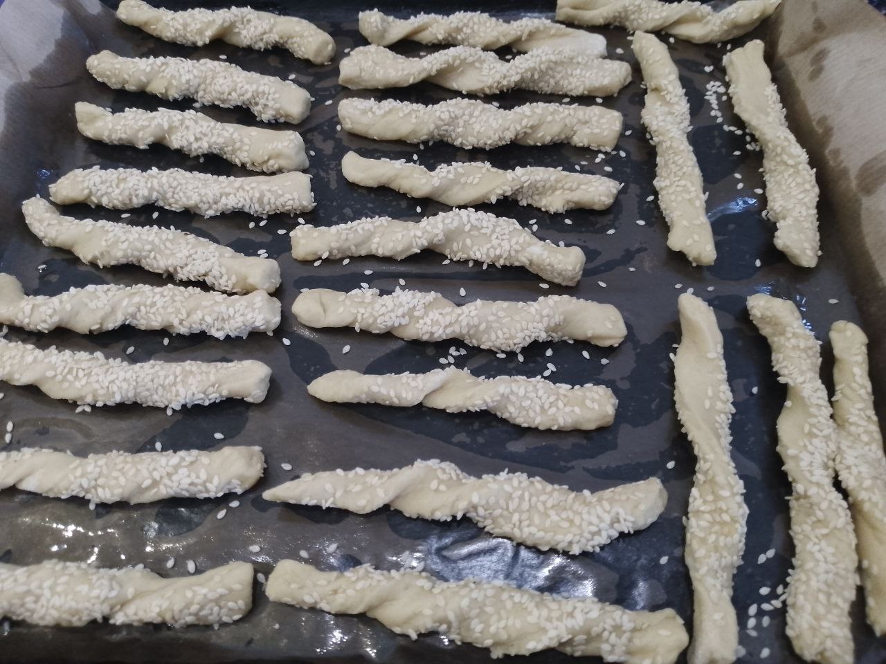Печенье с кунжутом и семенами льна, приготовленное из теста с вареными яйцами: Застилаем противень пергаментом и выкладываем на него полоски.