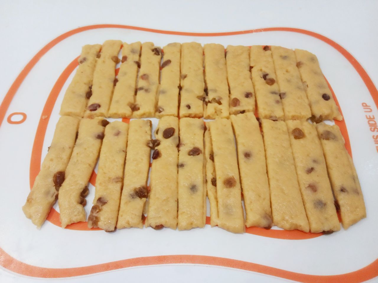 Рассыпчатое печенье с изюмом, на растительном масле: Каждую часть разрезаем на полоски длиной около 10 см и шириной 1,5-2 см.