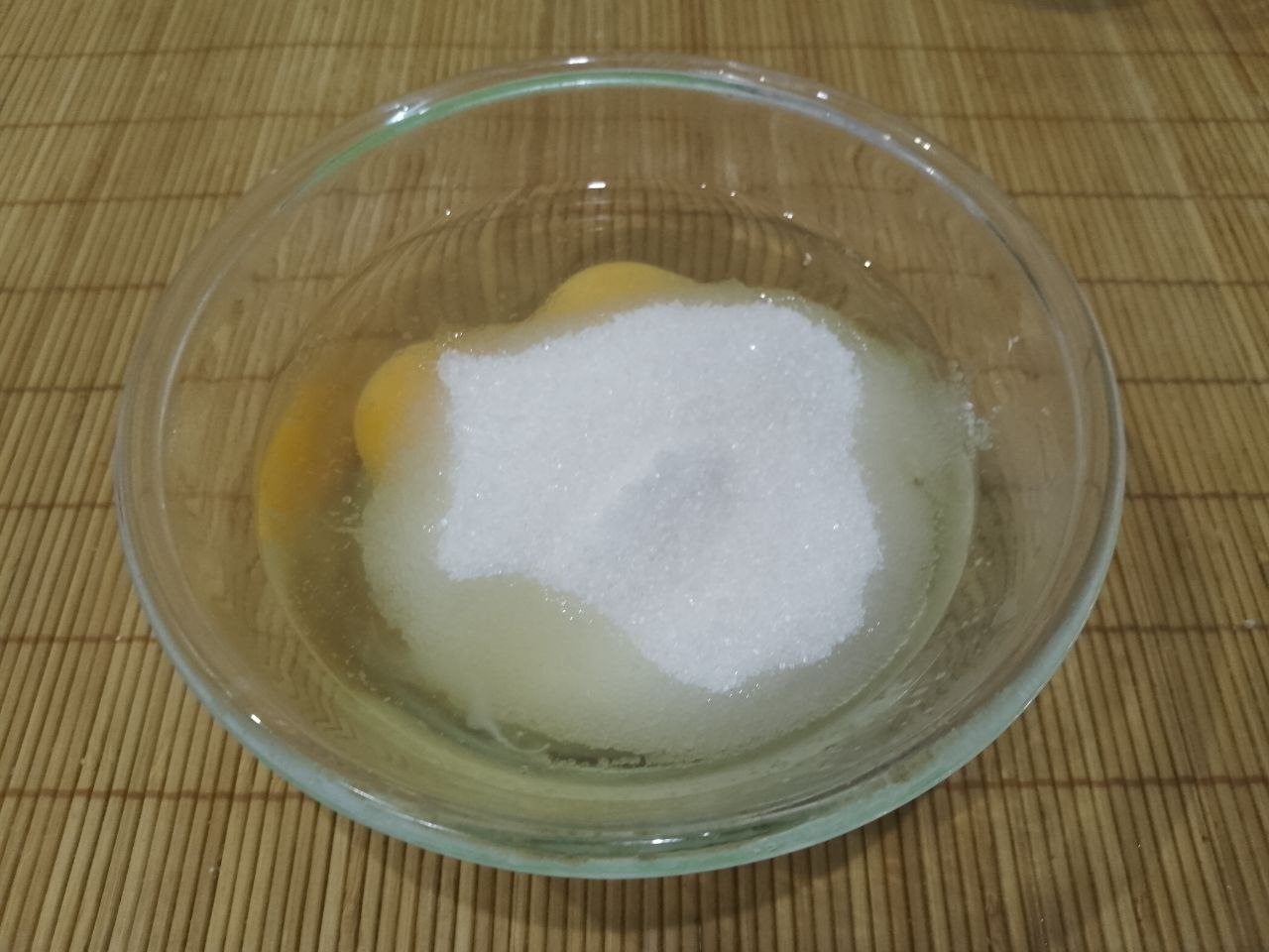 Домашнее мандариновое печенье, просто и вкусно: Яйца разбиваем в посуду для замешивания теста. Один желток отбираем для смазывания печенья. Добавляем сахар и