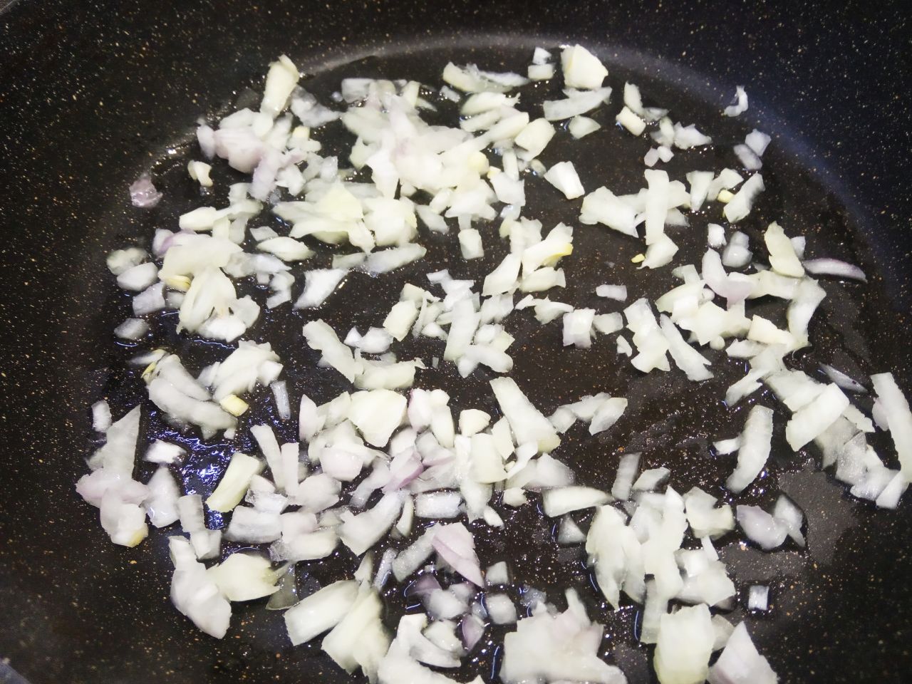 Картофельные пирожки с начинкой из куриного филе и лука: Разогреваем сковороду с растительным маслом, кладем лук и обжариваем до золотистого цвета.