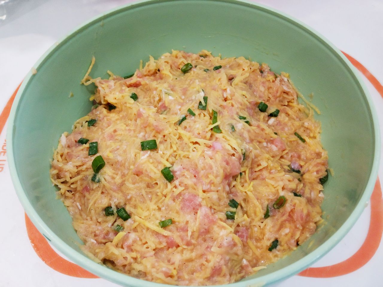 Котлеты из тертого картофеля, фарша и зеленого лука, вкусно и сытно: В посуде или миске соединяем отжатый тертый картофель, фарш, измельченные чеснок и зелёный лук, яйцо или