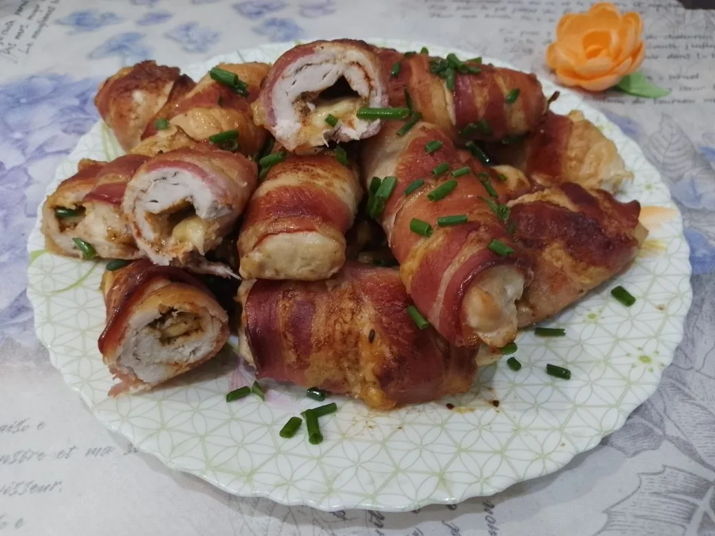 Куриное филе запеченное в беконе, с начинкой из твердого сыра: Запеченные рулетики выкладываем на блюдо и посыпаем зеленью.