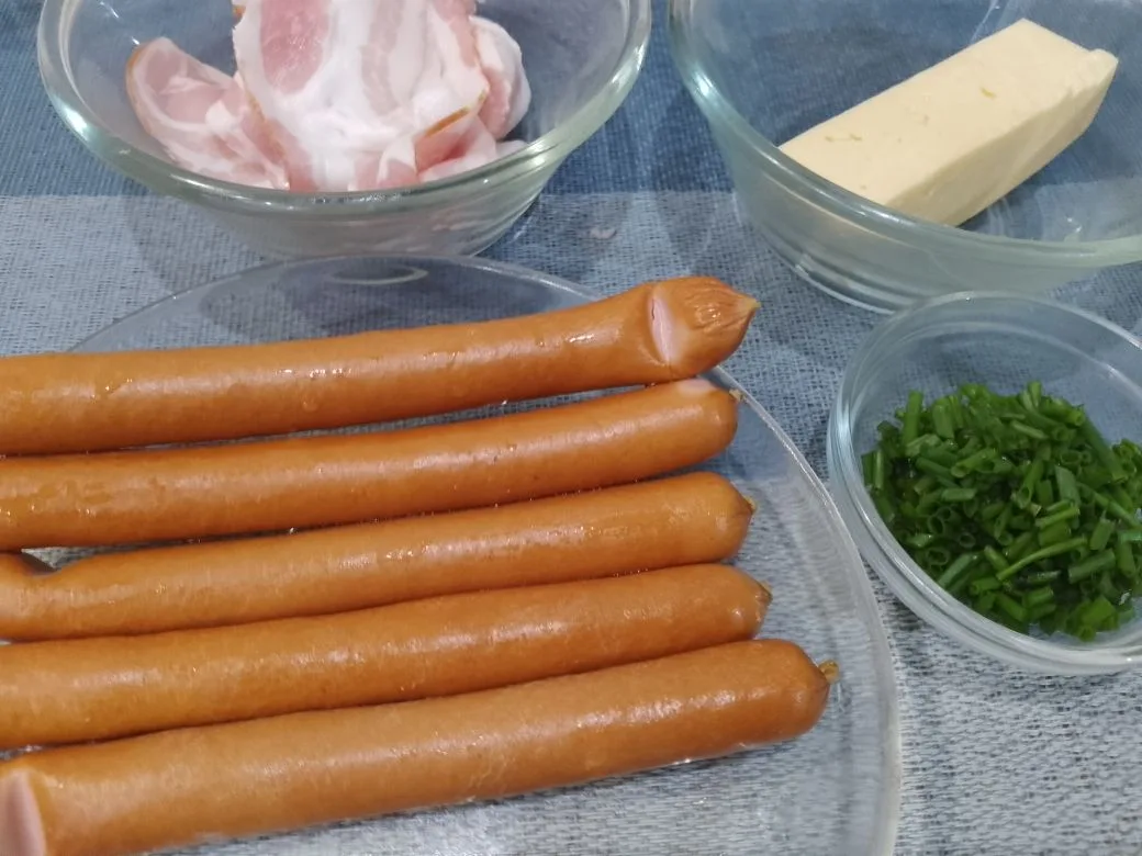 Обжаренные на сковороде, сосиски с сыром, в беконе