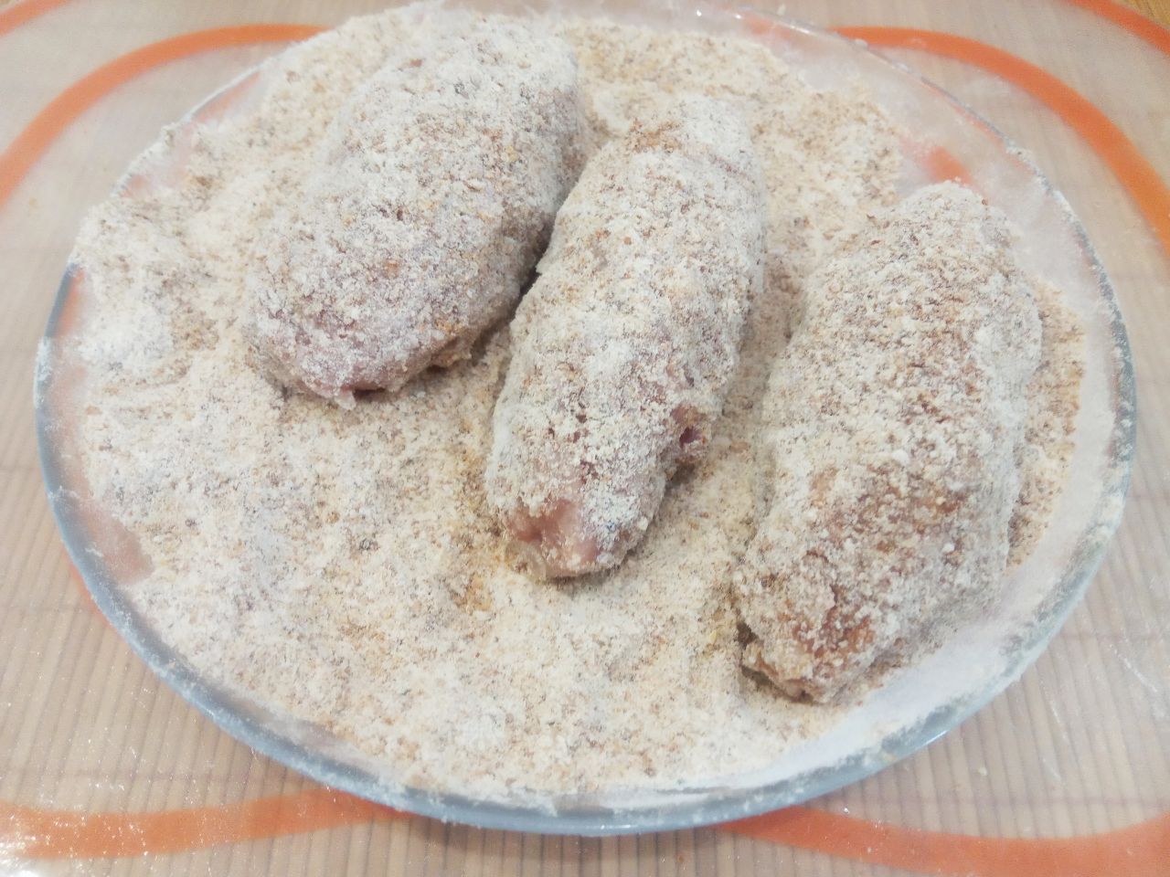 Домашние мясные котлеты, с начинкой из сыра, вкусные и аппетитные: Обваливаем котлеты в панировочной смеси.