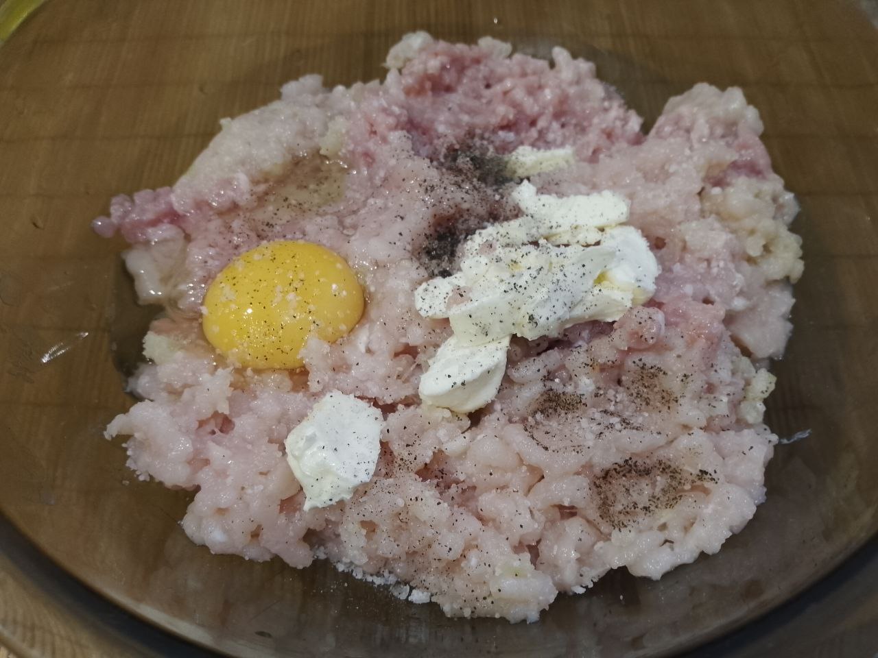 Котлеты с начинкой из яиц и сыра, в кляре, вкусные и сытные: В фарш добавляем лук, чеснок, яйцо, сливочное масло и специи, тщательно котлетную массу перемешиваем.