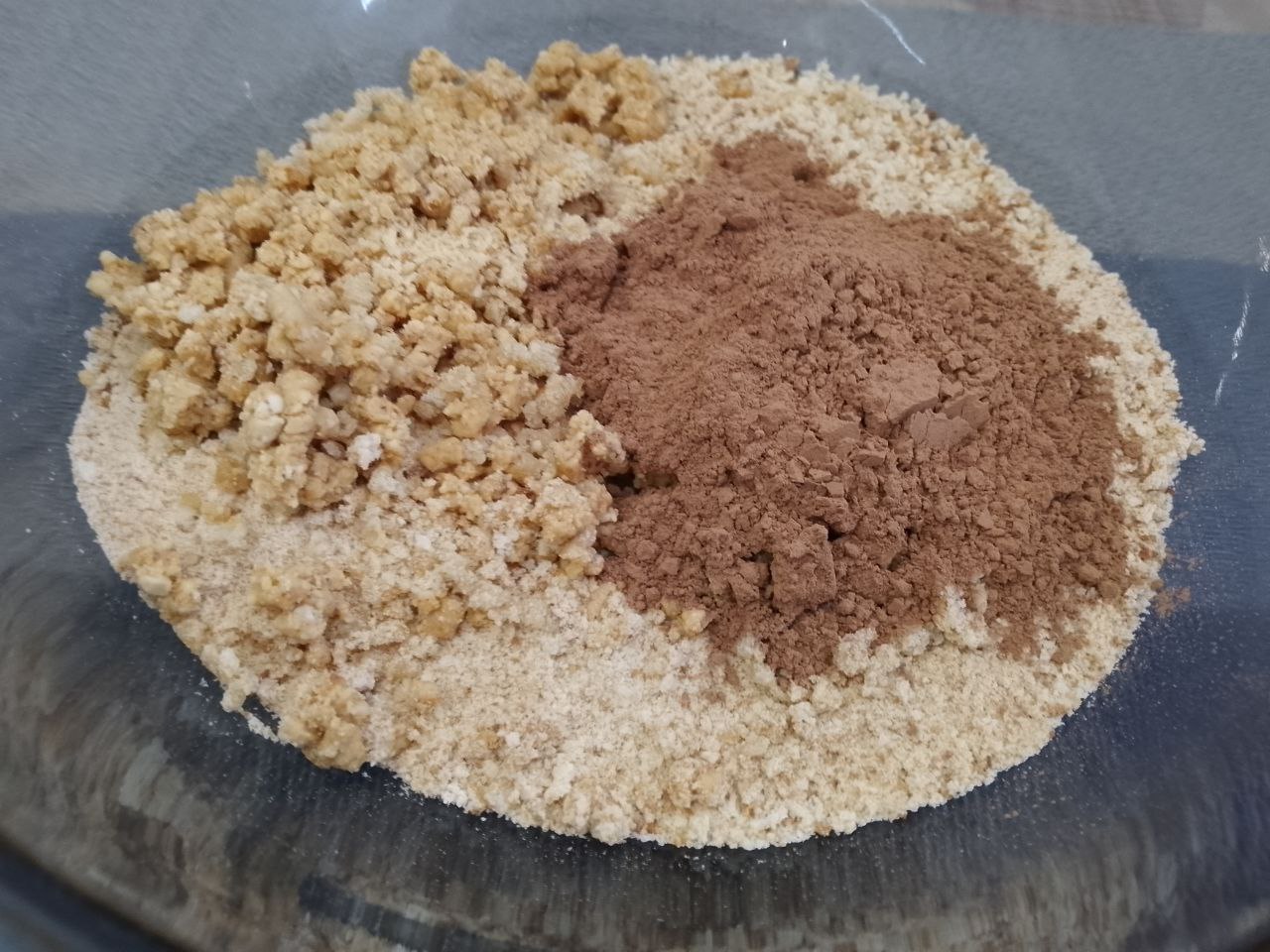 Домашние пирожные «Картошка», вкусно и просто: В чаше соединяем сухари, какао и молотые орехи, перемешиваем.