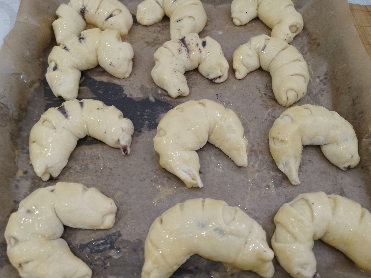 Рогалики из сдобного дрожжевого теста, с начинкой из мака и ягод: Противень застилаем пергаментом и укладываем рогалики, оставляем на 20 минут.