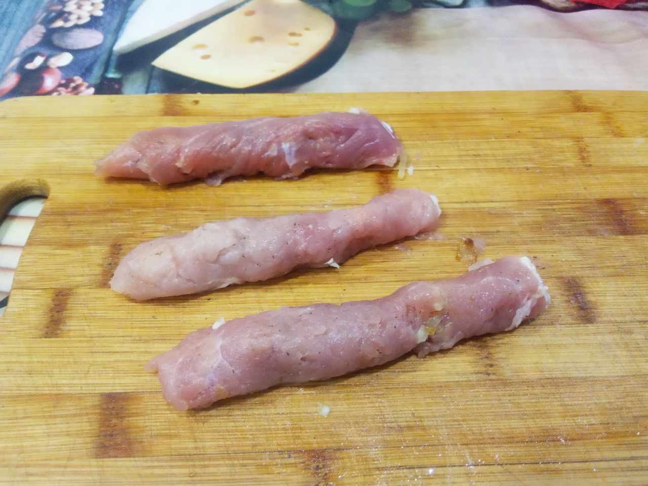 Мясные пальчики с начинкой из жареного лука: Кусочки свинины сворачиваем рулетиком и скрепляем зубочистками.
