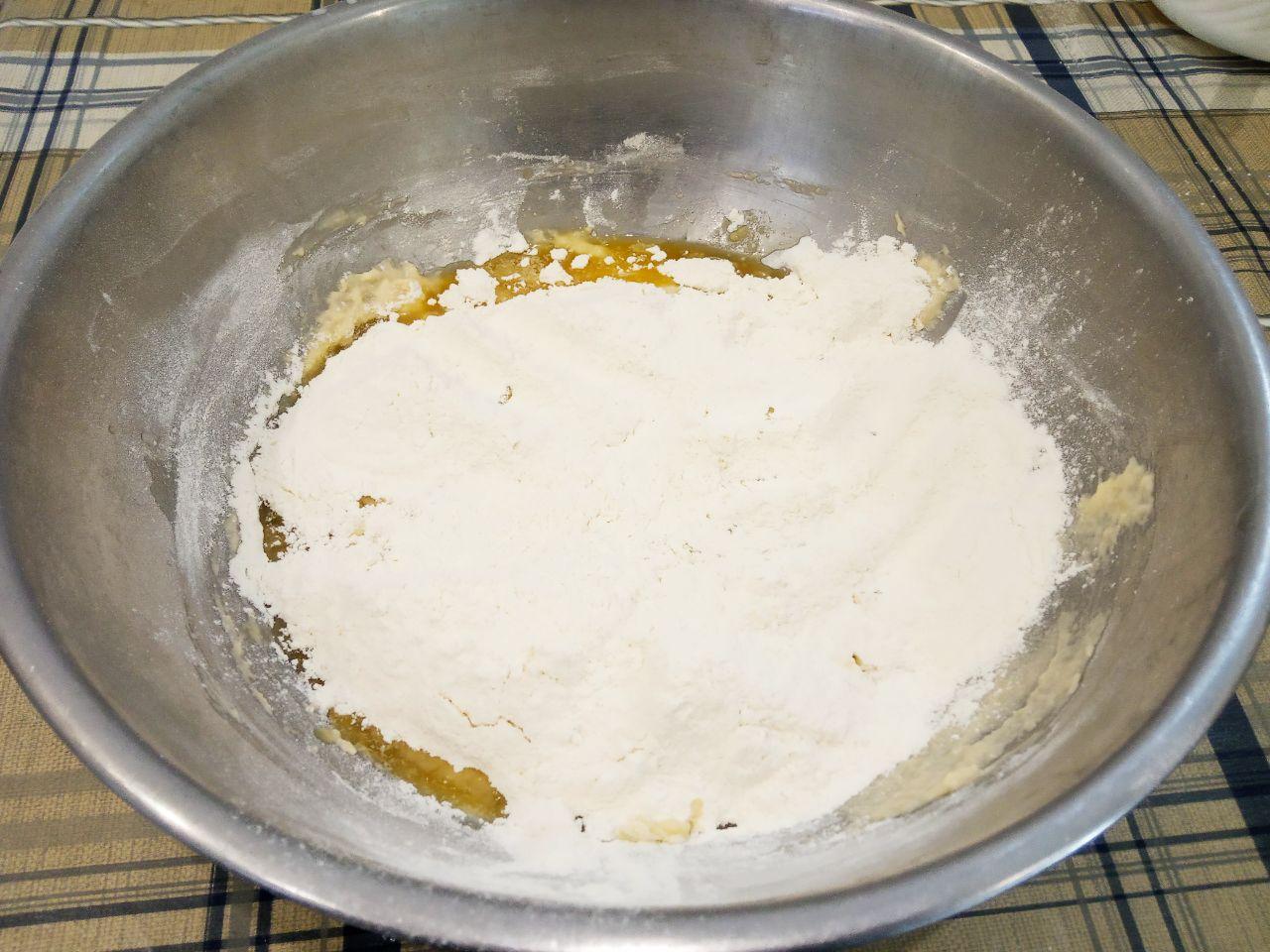 Пирог из дрожжевого теста с шоколадной крошкой: Всыпаем остальную муку и растопленное сливочное масло, хорошо вымешиваем пока тесто не станет отставать от