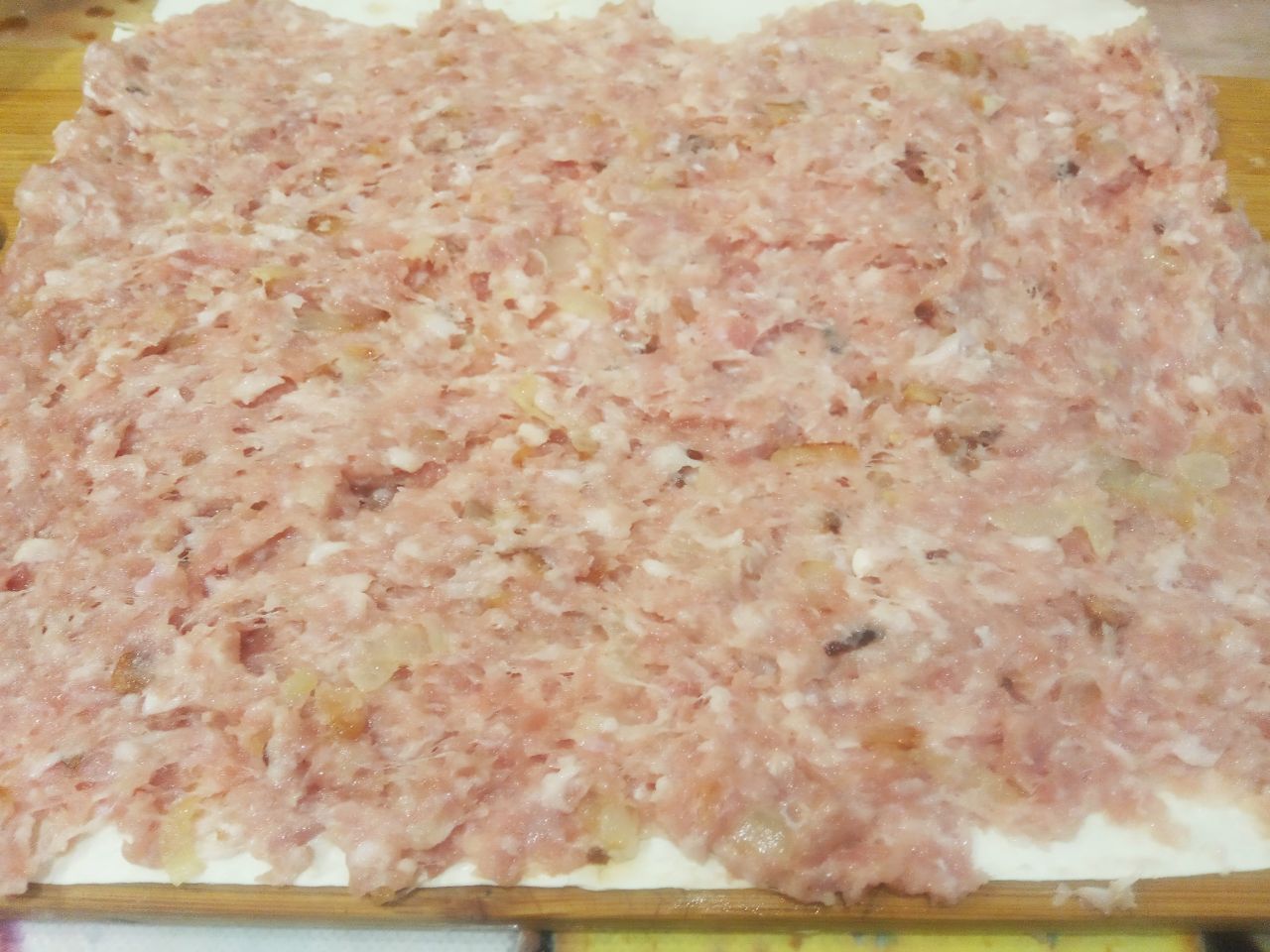 Рулет из лаваша с фаршем, в духовке: Мясную начинку разделяем на две половины и одну половину равномерно распределяем по листу лаваша.