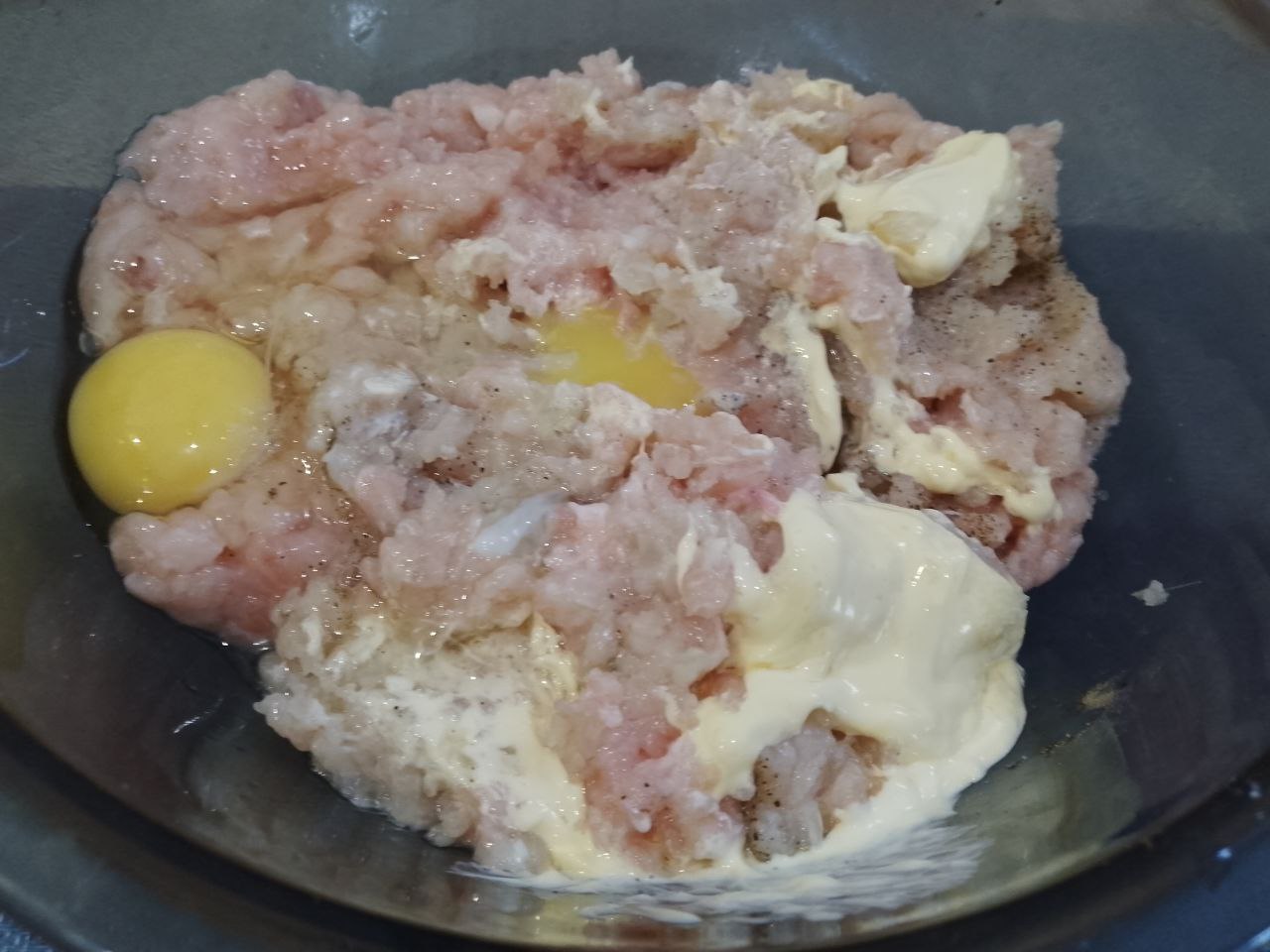 Рулетики из куриного фарша в беконе, в духовке: Соединяем фарш, яйца, лук и чеснок в чаше. Добавляем соль, перец по вкусу и майонез, тщательно перемешиваем.
