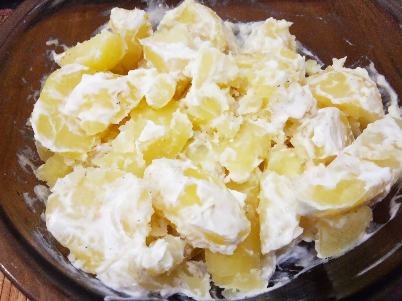 Запеченный молодой картофель в сметане и сыре: Складываем картофель в миску, добавляем перец молотый, сухой чеснок и сметану. Картофель перемешиваем