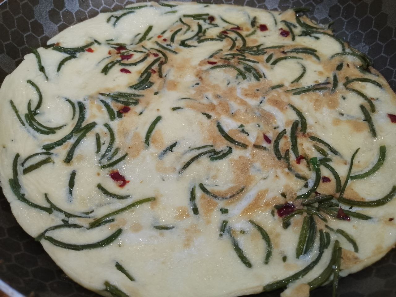 Чесночные стрелки с яйцами и острым перцем: Сковороду накрываем крышкой на три минуты, затем переворачиваем на другую и обжариваем пару минут.
