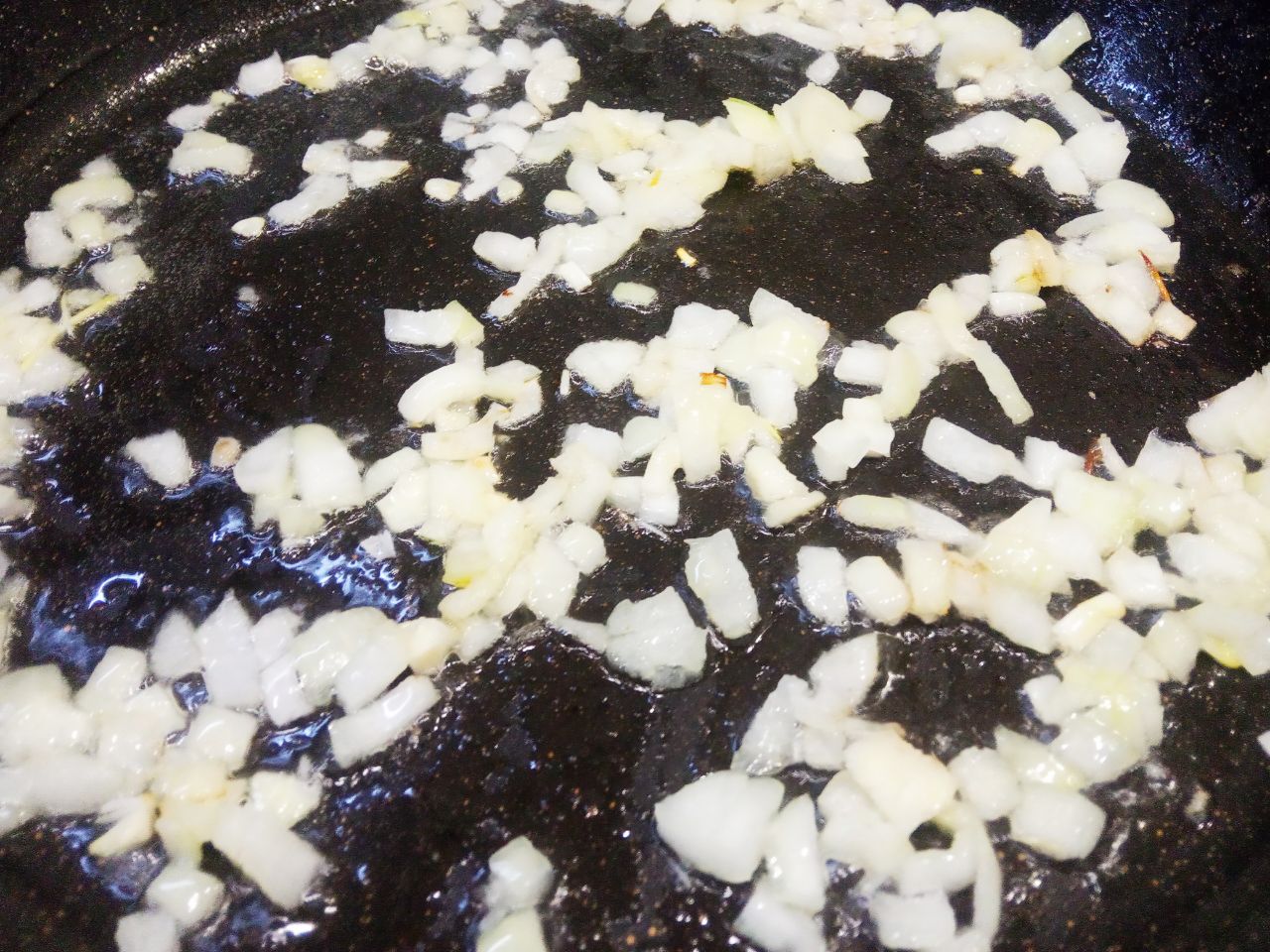 Макаронные гнёзда с фаршем и сыром на сковороде: Сковороду разогреваем с растительным или сливочным маслом, кладем лук и обжариваем до золотистого цвета.