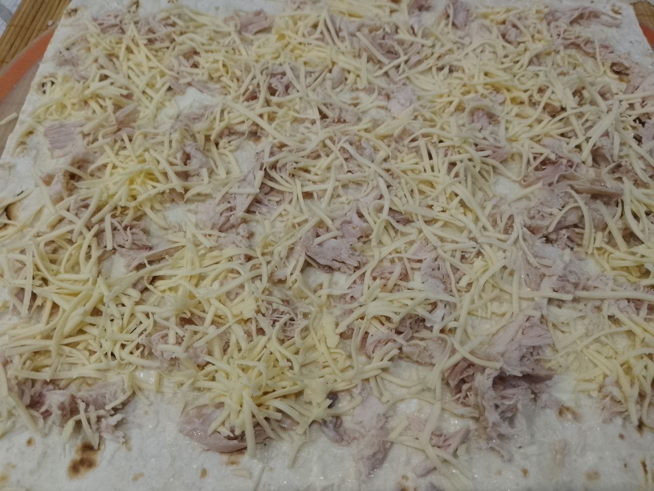 Вкусная закуска из лаваша, куриного филе и сыра, на сковороде: Сверху посыпаем тертым сыром.