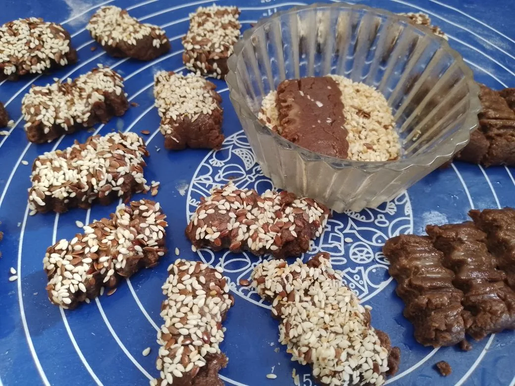 Шоколадное песочное печенье с кунжутом и кокосовой стружкой: Одну часть полосок смазываем и обваливаем в кунжуте, вторую в кокосовой стружке.
