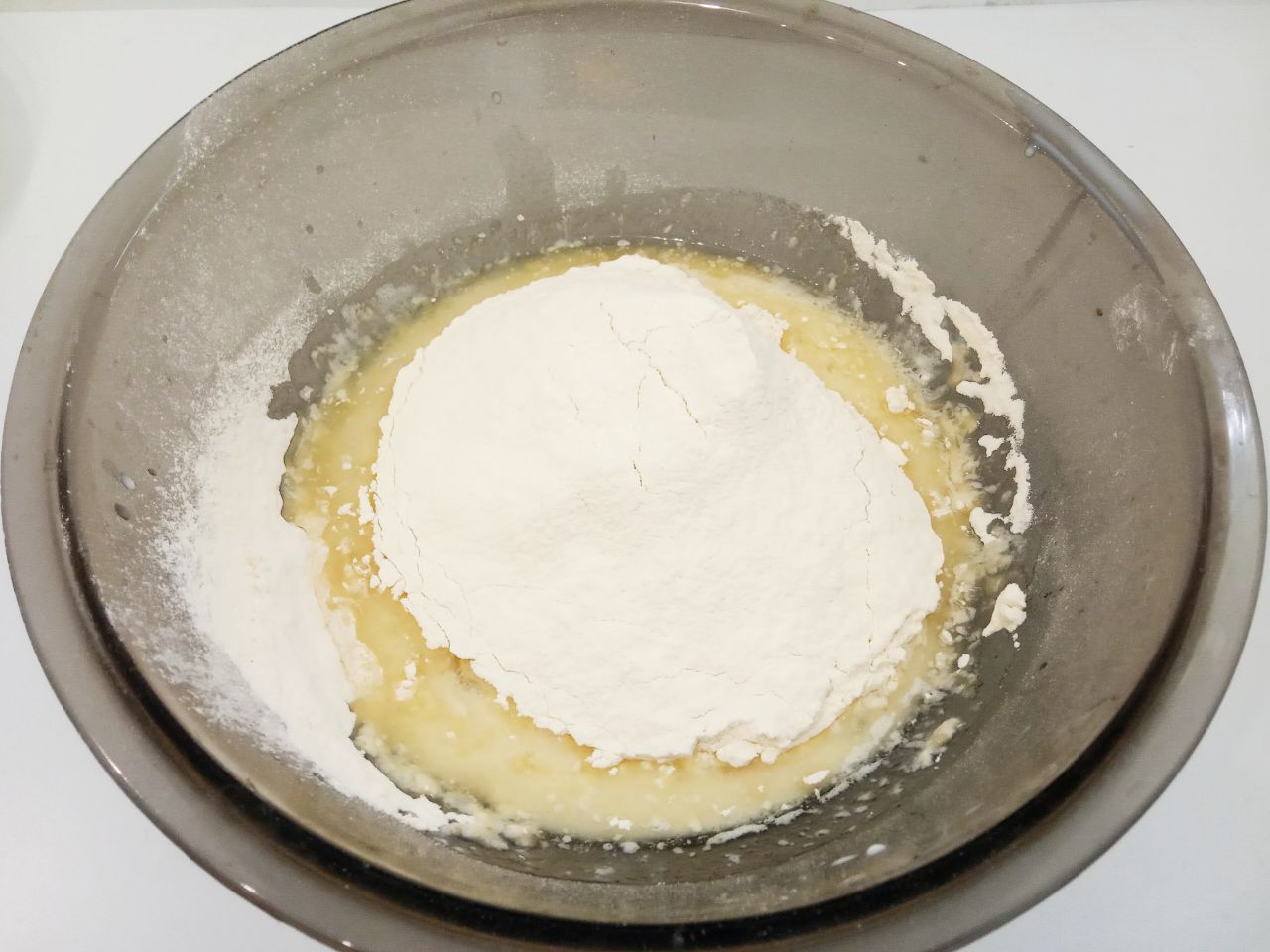 Булочки с изюмом, воздушные и мягкие: Муку просеиваем через мелкое сито и смешиваем с солью, перемешиваем. Половину добавляем в смесь, размешиваем
