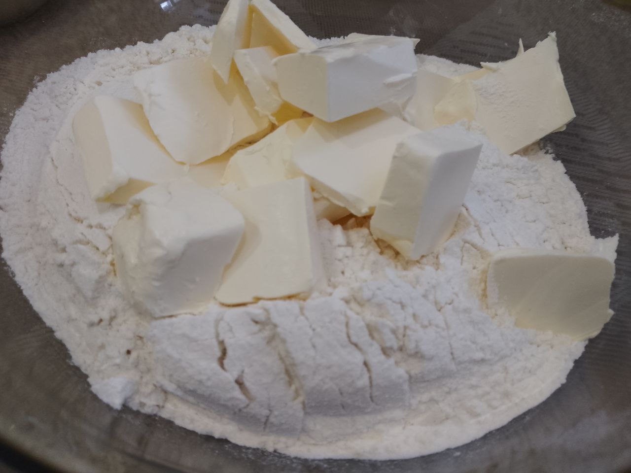 Пирог песочный трехслойный с начинкой из кураги, лимона и орехов: Добавляем щепотку соли и размягченное сливочное масло, перетираем в мучную крошку. Отделяем 2 столовые ложки