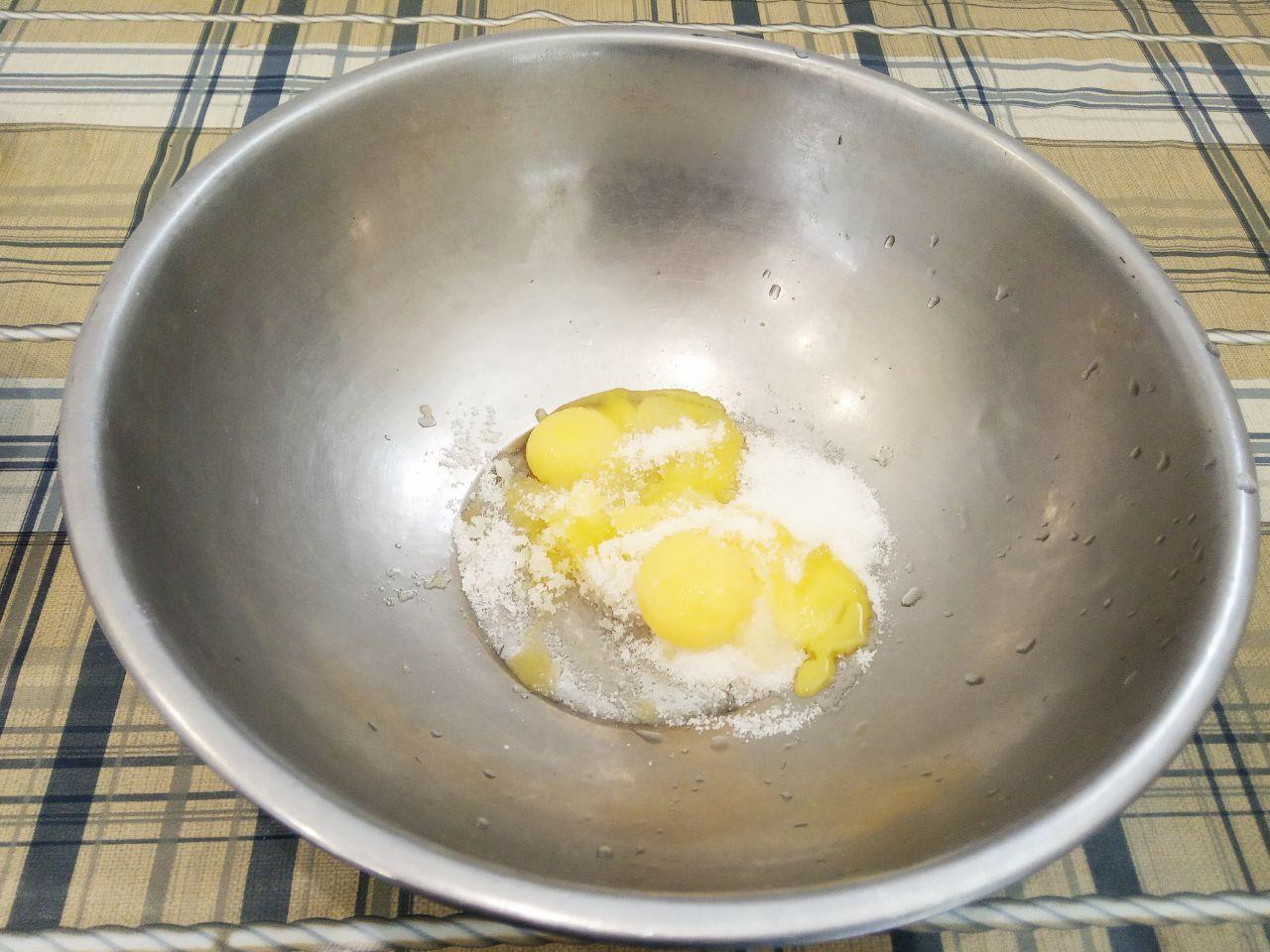 Булочки с шоколадной крошкой из дрожжевого теста на желтках: Добавляем в желтки сахар, ванильный сахар и щепотку соли, тщательно растираем.
