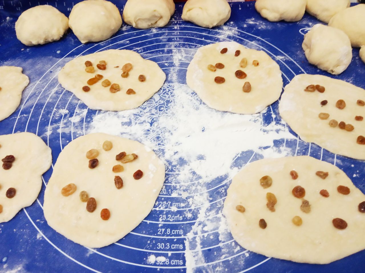 Воздушные и мягкие булочки, на сметане, с изюмом и корицей: Колобки для булочек с изюмом тонко раскатываем, смазываем маслом и распределяем изюм.