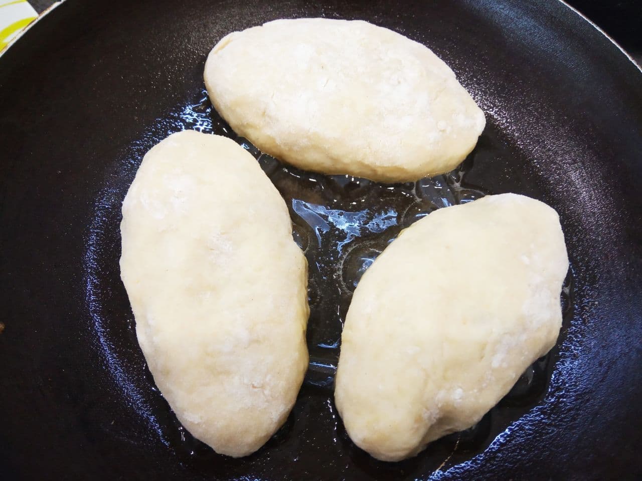 Пирожки с мясной начинкой из картофельного дрожжевого теста, жареные на сковороде: Обжариваем пирожки на небольшом количестве растительного масла на слабом огне с обеих сторон до готовности.