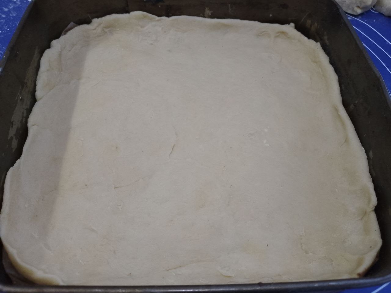 Пирог песочный трехслойный с начинкой из кураги, лимона и орехов: Лист теста перекладываем в форму, формируем бортики.