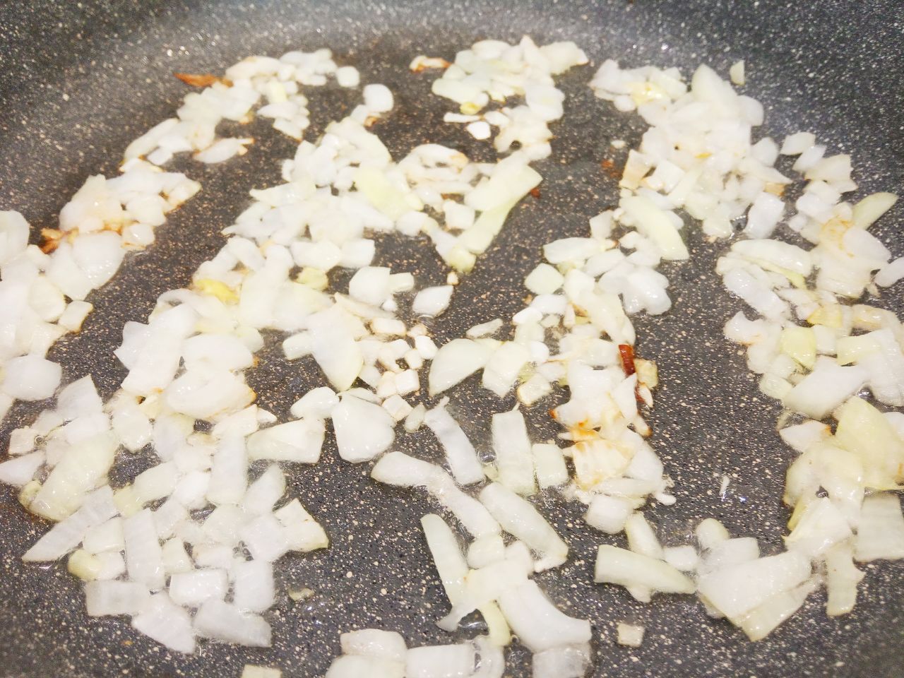 Картофельный рулет с мясной начинкой, запеченный в духовке: Разогреваем сковороду с растительным маслом и обжариваем лук до золотистого цвета.