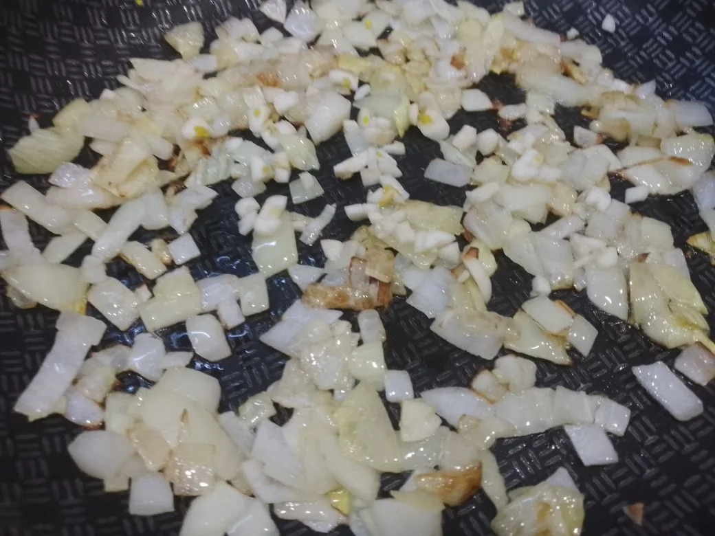 Тушеное мясо свинины с овощами: На той же сковороде обжариваем лук до золотистого цвета, затем добавляем измельченный чеснок и жарим еще
