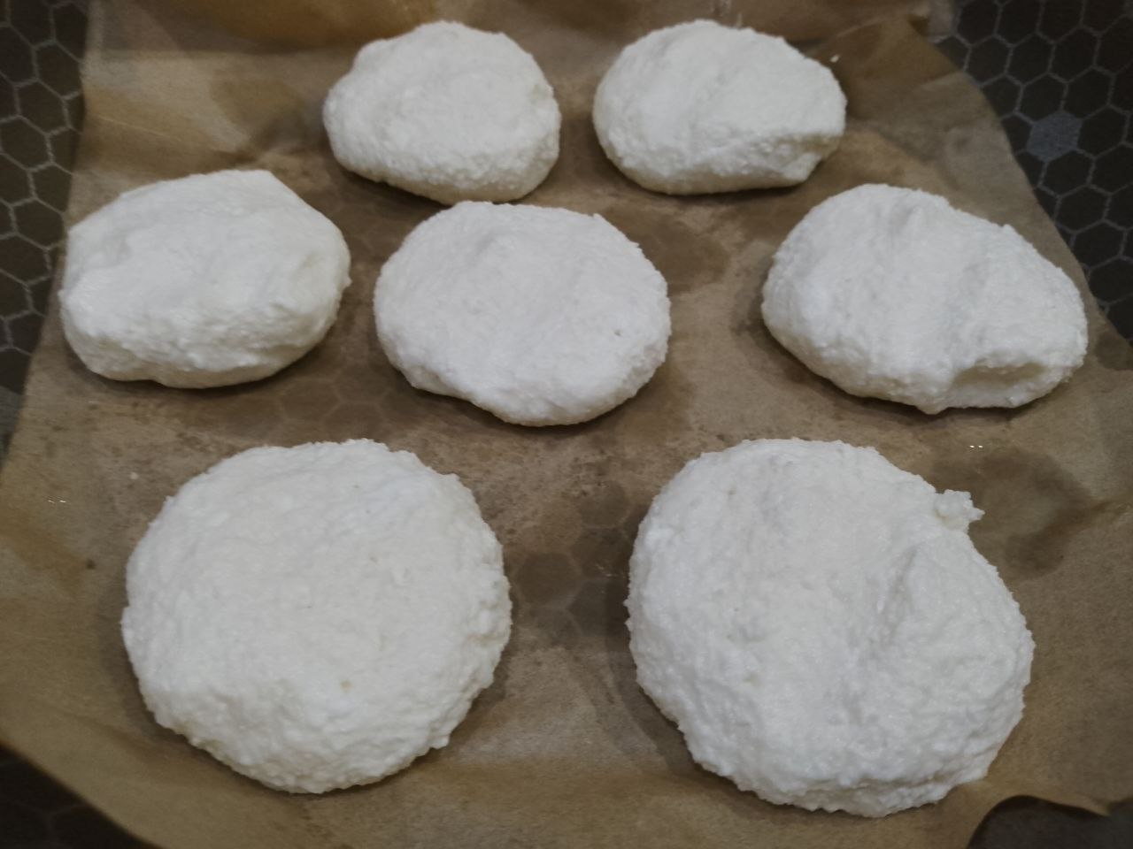 Сырники из творога, рисовой муки и кокосовой стружки: Влажными руками формируем сырники и укладываем на пергамент.