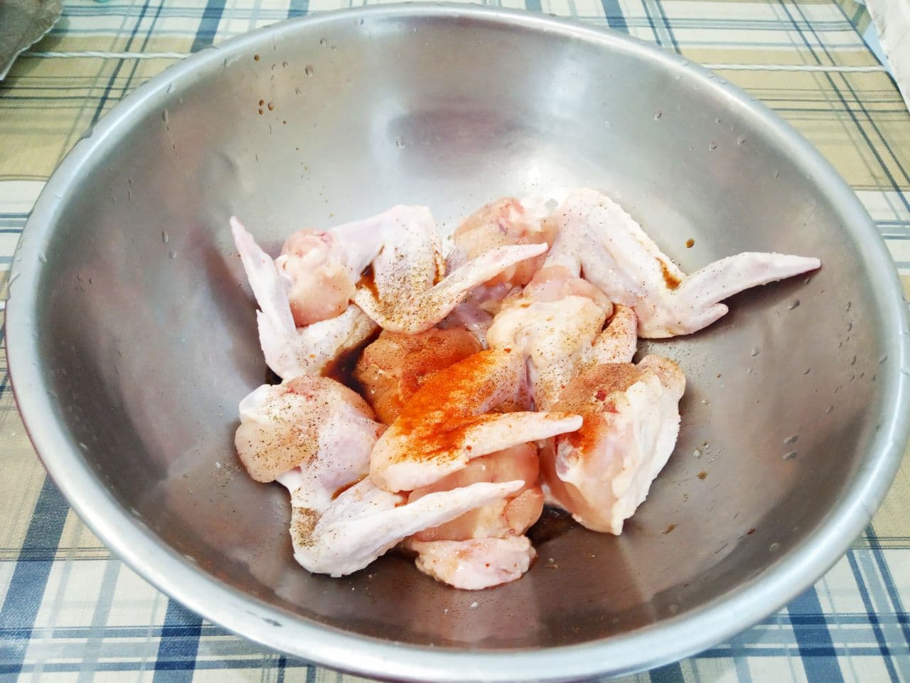 Сочные, аппетитные куриные крылышки в соевом соусе, яичном кляре и сухарях, запеченные в духовке: Складываем в посуду, солим и перчим по вкусу. Добавляем паприку, растительное масло, соевый соус и по желанию