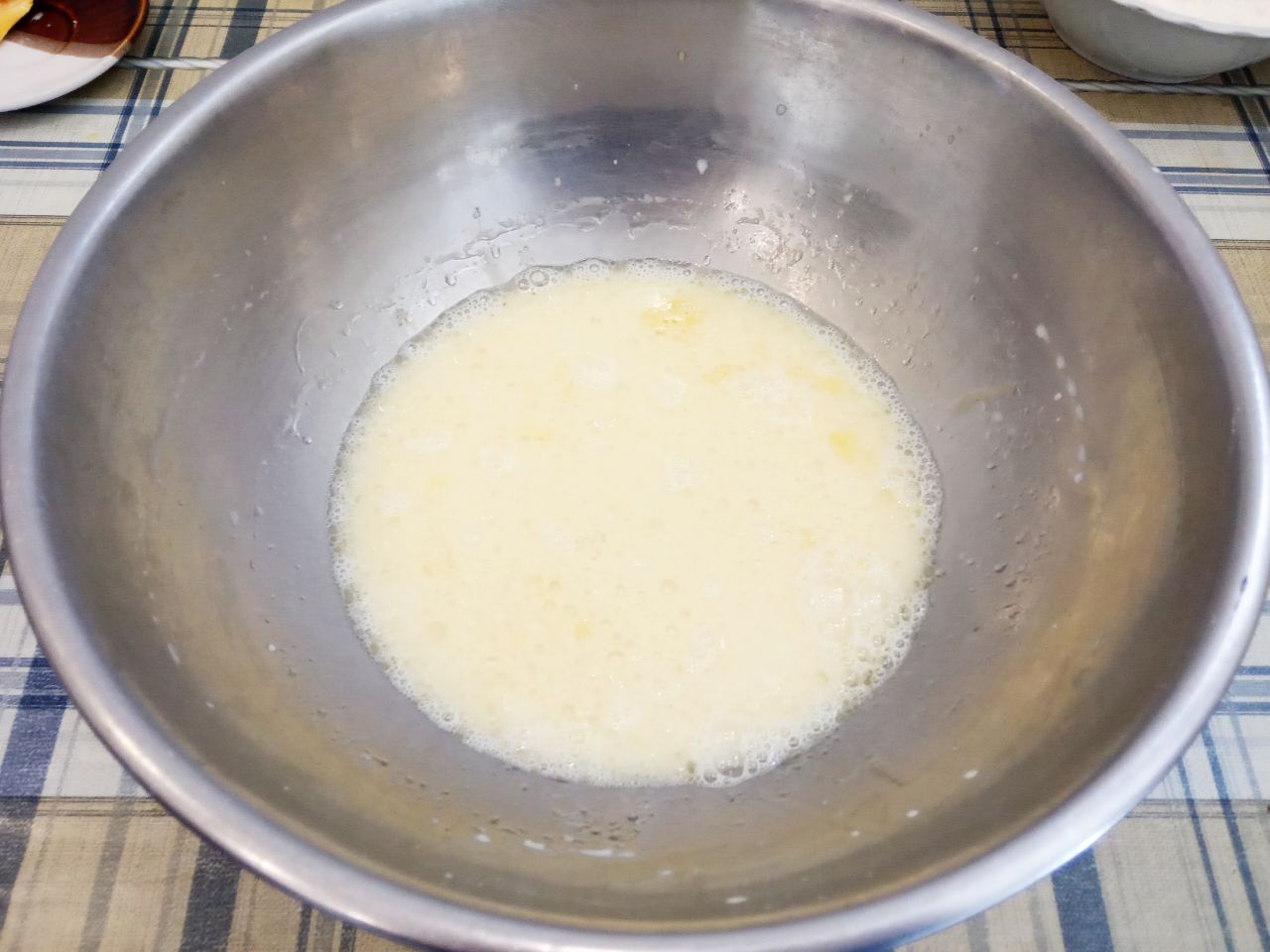 Булочки с изюмом в шоколадной глазури: В миску выливаем подошедшие дрожжи, растертые яйца с сахаром и растительное масло, размешиваем венчиком.