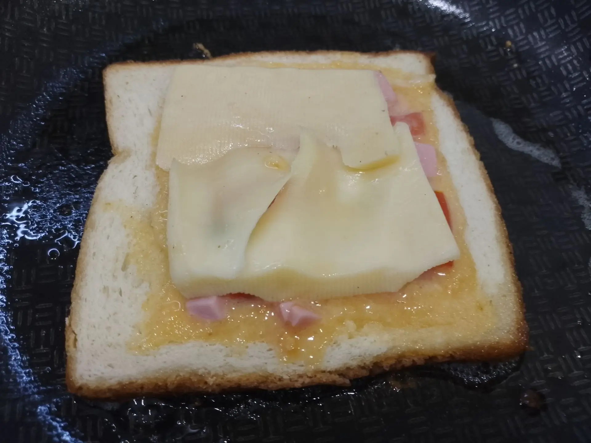 Бутерброды с начинкой из яиц, сыра, помидоров и зеленого лука, на сковороде: Затем кладем ломтики сыра и накрывай вырезанной серединой хлеба.